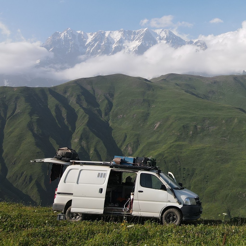 Van de famille nomade en voyage, symbole de liberté et d'apprentissage à distance avec Gravir : cours de mathématiques en ligne pour enfants déscolarisés temporairement.
